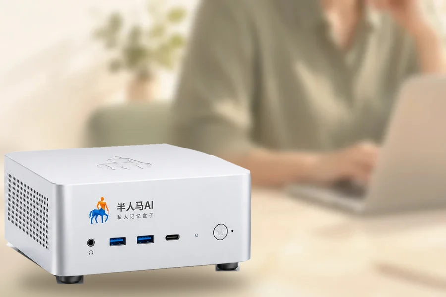 万象盒子放在书桌上，身后是正在用电脑工作的人（示意）